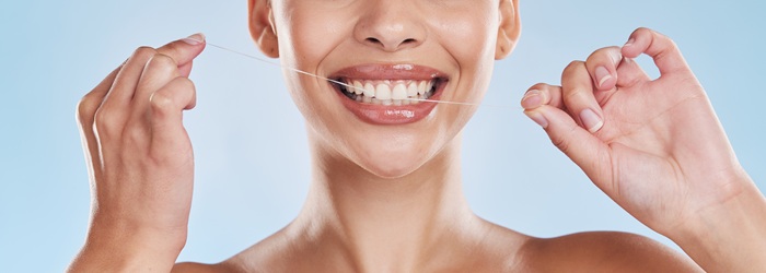 mujer usando hilo dental | Cuidado Dental | Higiene Bucal | Clínica dental Legazpi