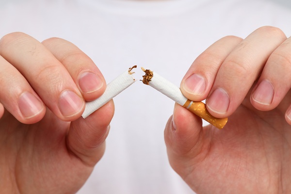 Manos partiendo un cigarro | Implante Dental | Dentista Arganzuela | Estética Dental