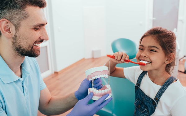 Dentista enseñando a niña como lavarse los dientes | | revisiones dentales infantiles | Clínica Dental Madrid Río | Clínica Larrañaga | Vuelta al Cole