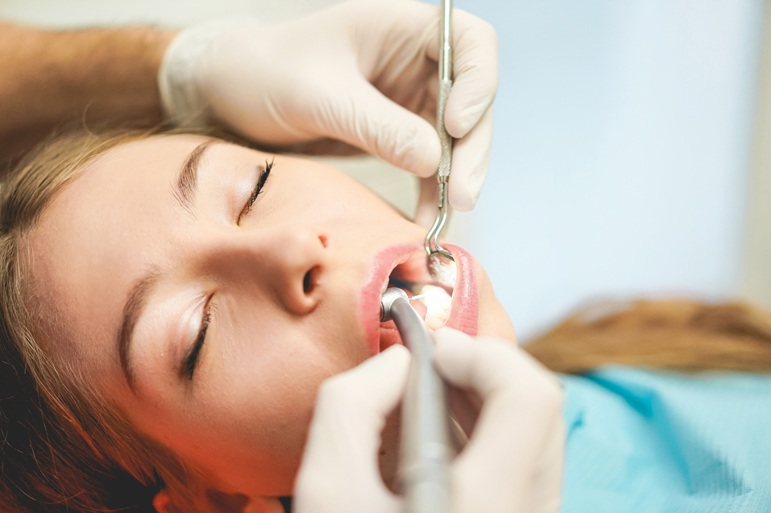 Mujer al que se le está realizando limpieza dental profunda, curetaje | Diente Definitivo se Mueve | Clínica Dental Arganzuela